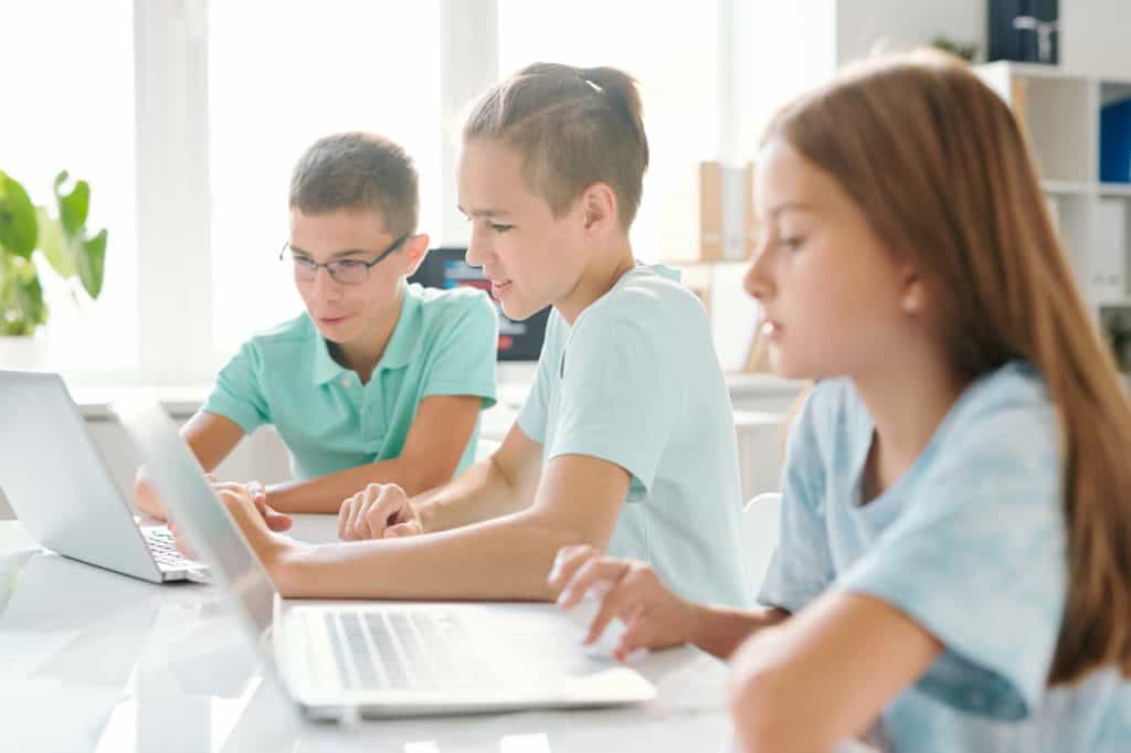 middle school children using laptops